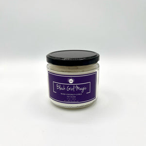 12 oz glass jar candle with cotton wicks and non-toxic fragrance. Soy blend wax scented with a refreshing blend of fresh flowers and light coconut, complemented by soothing musk and sandalwood base. Purple label reads 'Black Girl Magic.' Enhance self-care with pride and nostalgia for Black women.