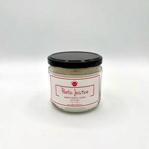 12 oz glass jar candle with cotton wicks and soy blend wax, crafted to enhance self-care and celebrate culture. White label with red text reads 'Poetic Justice'. Fragrance features notes of amber and vanilla blended with cardamom and ozone for a fresh, masculine scent.